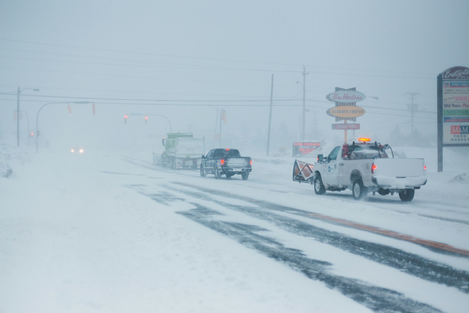 vehicles passing on road covered with snow