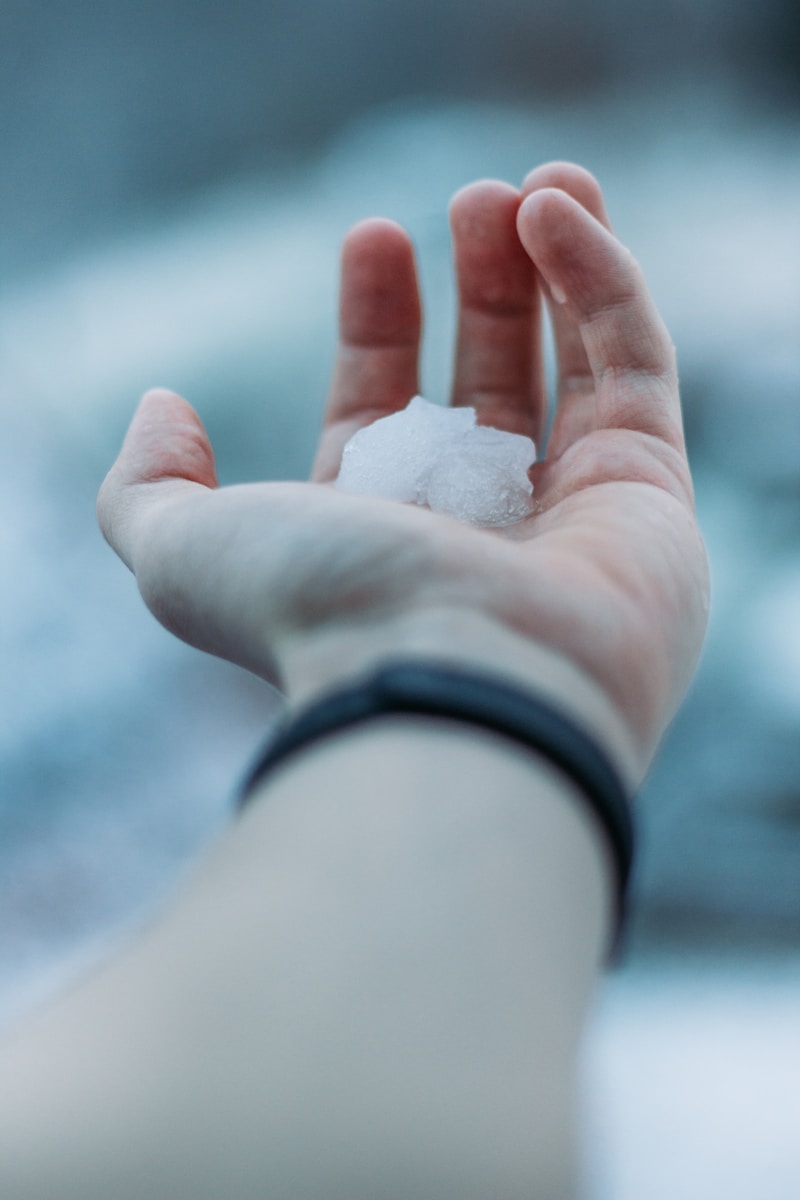 person holding white snow on hand